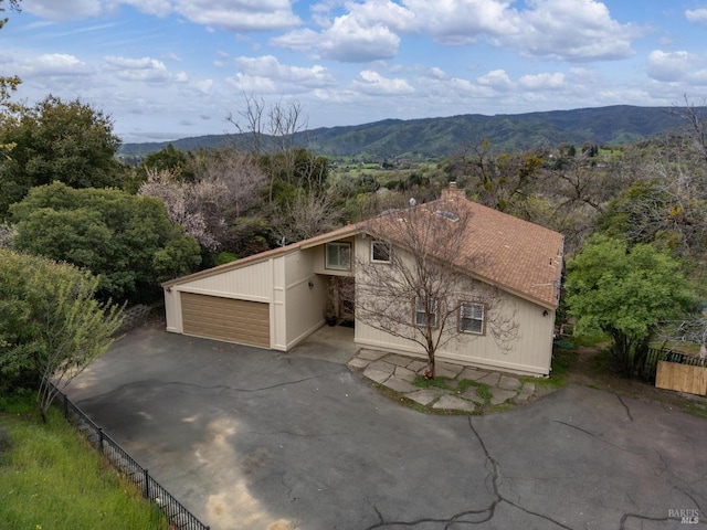 view of front of home with a chimney, fence, and a mountain view