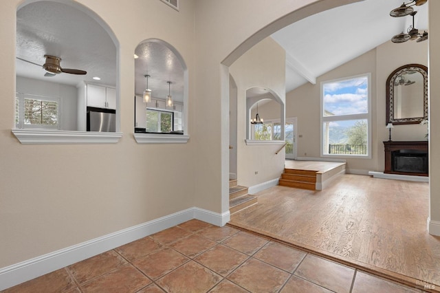 interior space with a healthy amount of sunlight, a fireplace with raised hearth, and baseboards