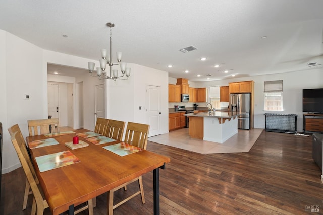 dining space with recessed lighting, wood finished floors, visible vents, and a chandelier