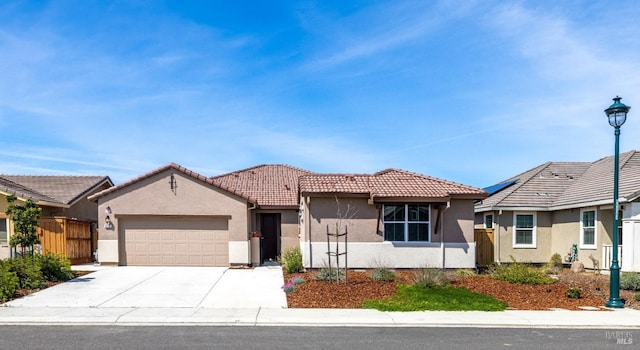 view of front of home featuring stucco siding, fence, concrete driveway, an attached garage, and a tiled roof