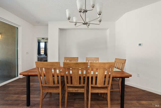 dining area featuring a textured ceiling, wood finished floors, baseboards, and a chandelier