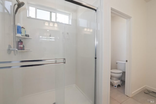 bathroom featuring a shower stall, toilet, and tile patterned floors