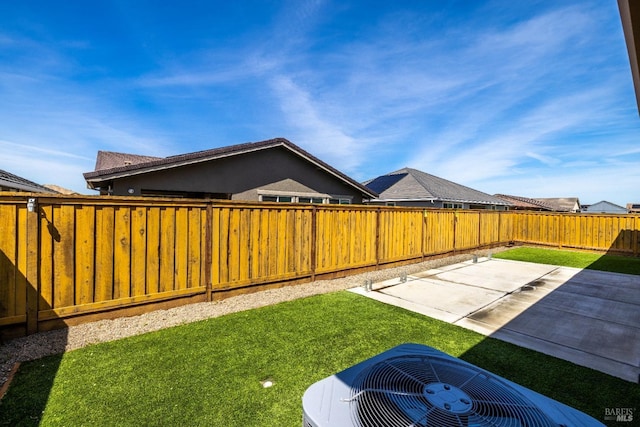 view of yard featuring a fenced backyard, central AC unit, and a patio