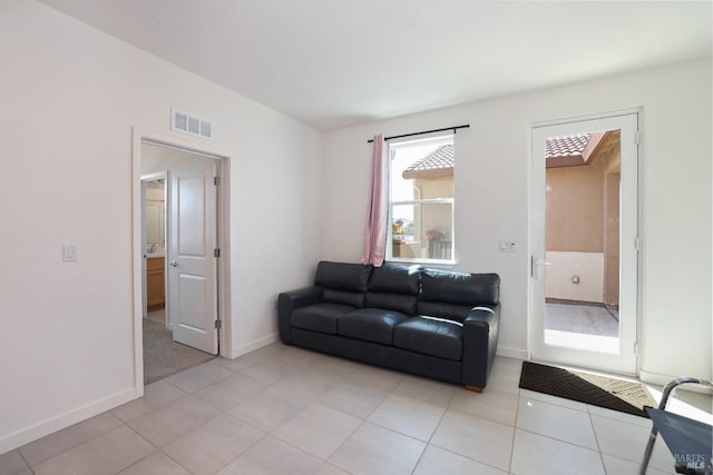 living room with light tile patterned floors, baseboards, and visible vents