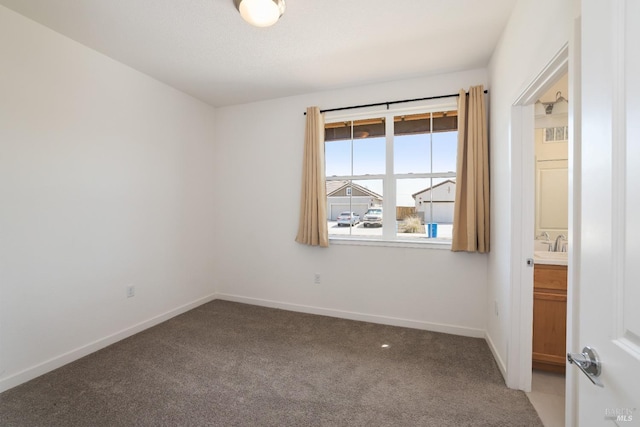 unfurnished room with baseboards and light colored carpet