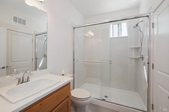 bathroom featuring vanity, toilet, visible vents, and a stall shower