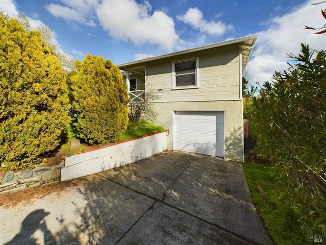 view of home's exterior with stucco siding, driveway, and a garage