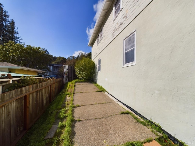 view of property exterior featuring fence and stucco siding