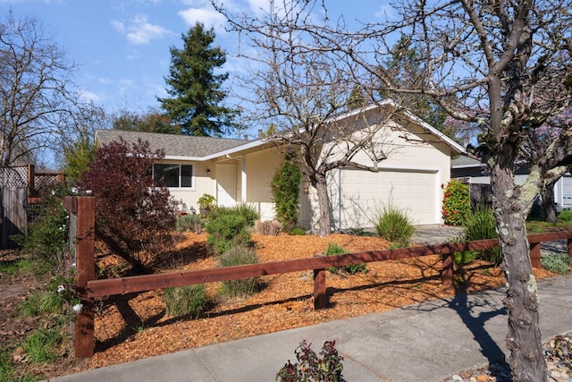 view of front of house with a shingled roof, fence, driveway, and an attached garage