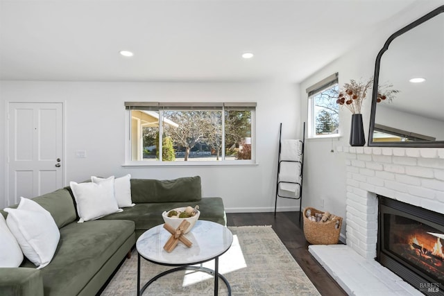 living room with recessed lighting, dark wood-style flooring, a fireplace, and baseboards