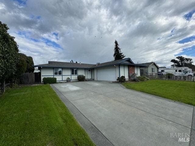 ranch-style house featuring an attached garage, fence, concrete driveway, and a front yard