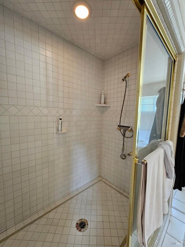 full bath with a shower stall and tile patterned flooring