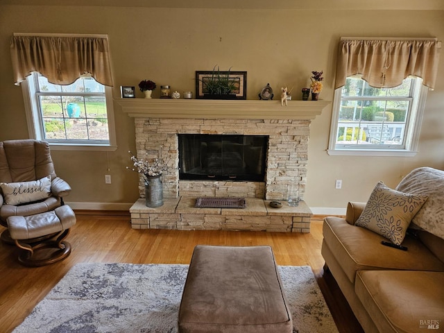 living room with baseboards, a fireplace, and wood finished floors