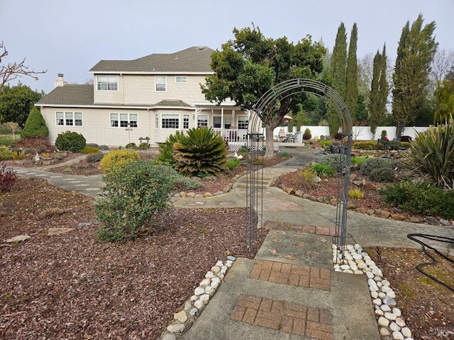 back of house featuring a chimney and fence