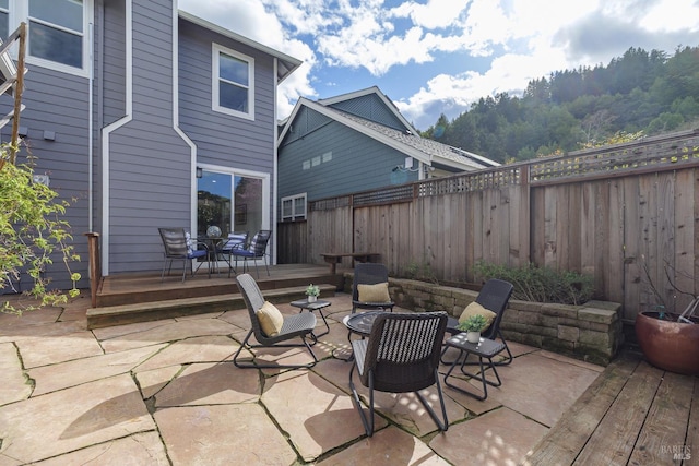 view of patio featuring a deck, outdoor dining space, and a fenced backyard