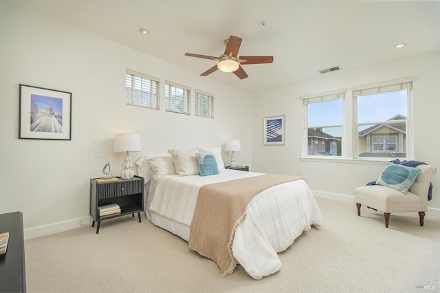 bedroom with visible vents, light colored carpet, baseboards, and multiple windows