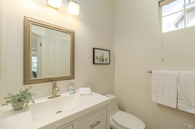 half bathroom with toilet and vanity