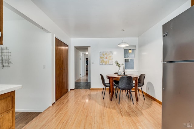 dining room featuring light wood-type flooring and baseboards