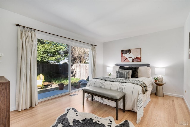 bedroom featuring access to exterior, visible vents, baseboards, and wood finished floors