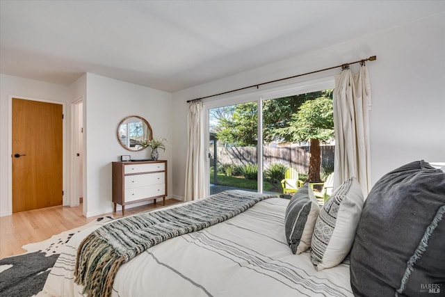 bedroom featuring access to outside, wood finished floors, and baseboards