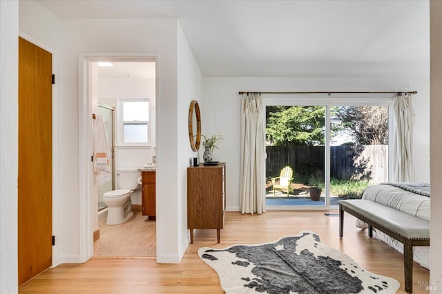 living area with light wood-style flooring and baseboards