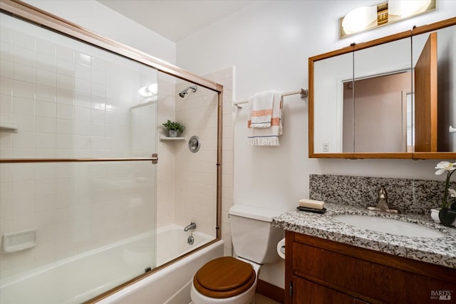 full bath featuring shower / bath combination with glass door, vanity, and toilet