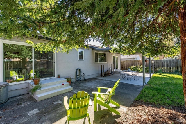 exterior space with a patio, fence, and stucco siding