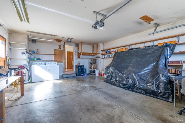 garage featuring a garage door opener, a workshop area, and separate washer and dryer