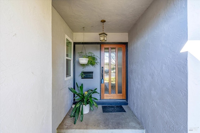 doorway to property featuring stucco siding