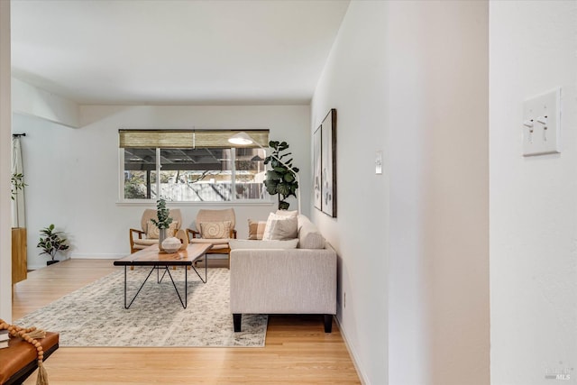 living area featuring baseboards and light wood-style floors