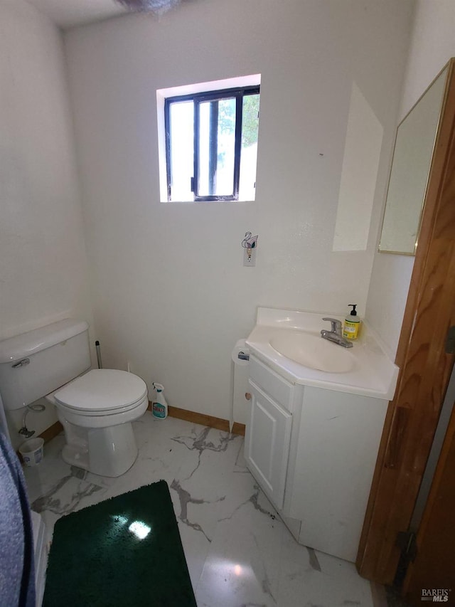 bathroom with toilet, marble finish floor, baseboards, and vanity