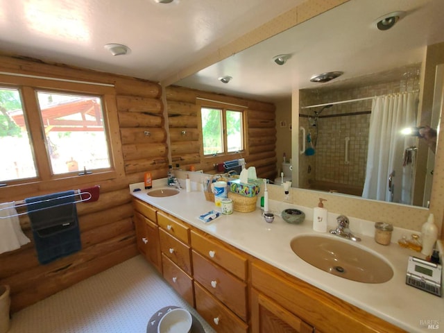 full bathroom with tiled shower, a sink, and double vanity