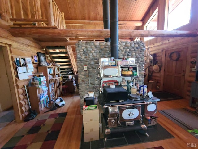 living area featuring a wood stove, wood ceiling, log walls, and wood finished floors