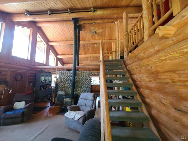 staircase featuring high vaulted ceiling, wood ceiling, beam ceiling, rustic walls, and a wood stove