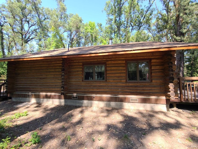 view of property exterior with crawl space and log siding