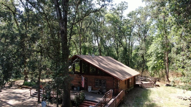 exterior space featuring a wooden deck and log siding