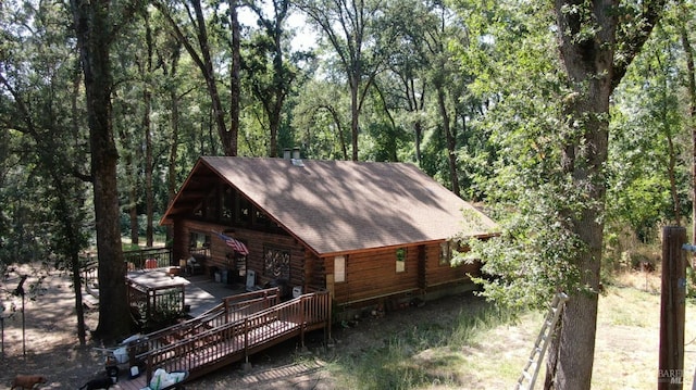 exterior space featuring a forest view and a deck