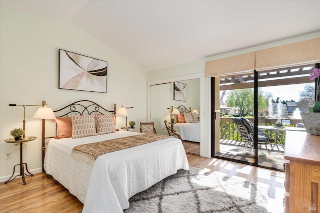 bedroom featuring lofted ceiling, access to outside, baseboards, and wood finished floors