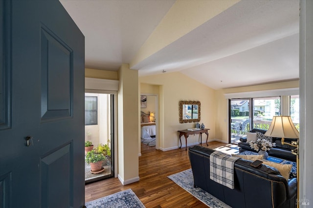 entrance foyer featuring lofted ceiling, dark wood finished floors, and baseboards