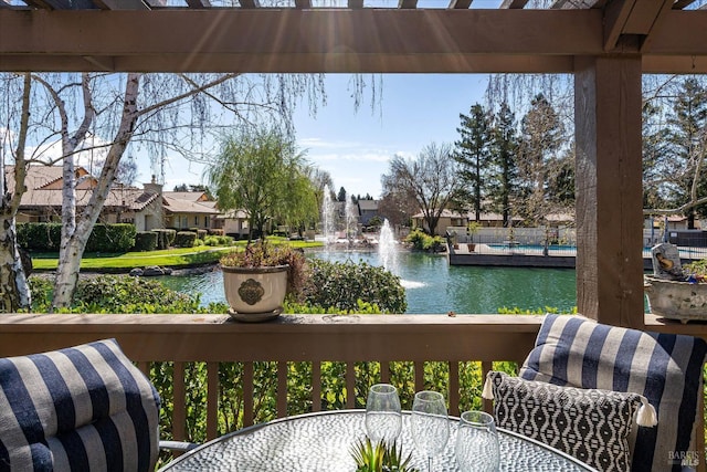 wooden deck featuring outdoor dining area and a water view