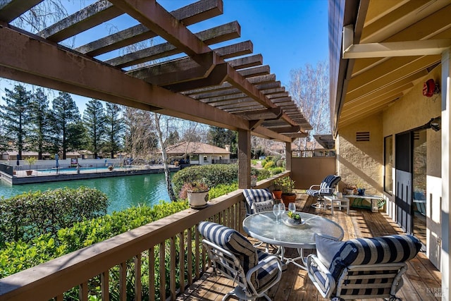 deck featuring a water view, a pergola, and outdoor dining space