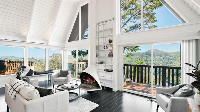 sunroom with a wood stove and vaulted ceiling with beams