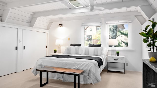 bedroom with vaulted ceiling with beams and light carpet