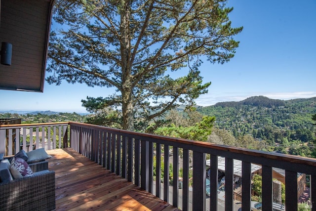 wooden terrace featuring a forest view and a mountain view