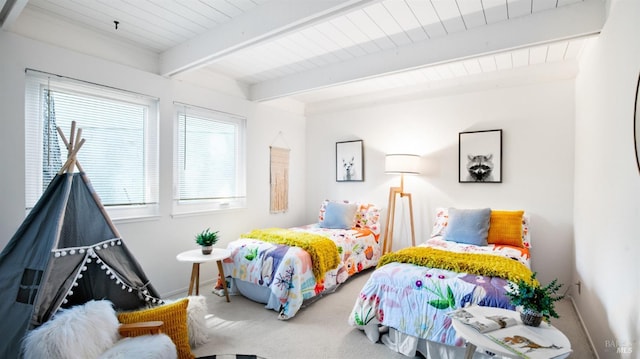 bedroom featuring beamed ceiling, carpet, and baseboards