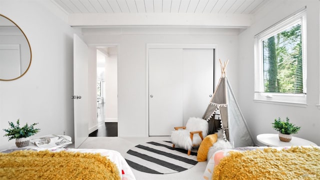 bedroom featuring a closet, wooden ceiling, and beamed ceiling