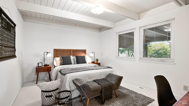 bedroom featuring carpet floors, beam ceiling, and baseboards