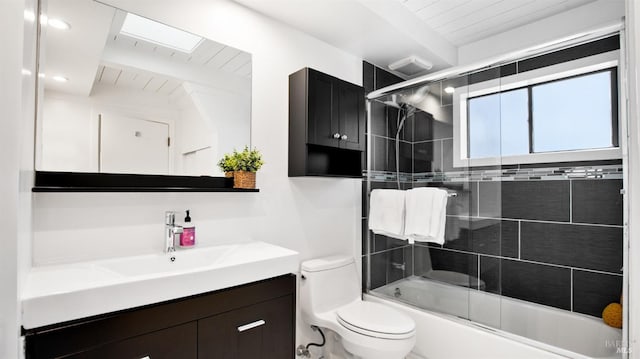 bathroom featuring enclosed tub / shower combo, vanity, and toilet