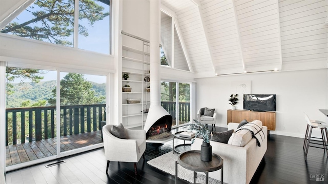 living room featuring visible vents, high vaulted ceiling, and a wealth of natural light