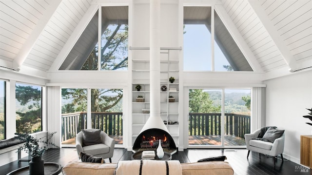 sunroom / solarium featuring lofted ceiling with beams, a warm lit fireplace, and wood ceiling